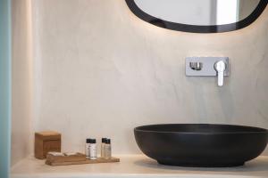 a bathroom with a black bowl sink on a counter at Caldera Cliff Illusion in Fira