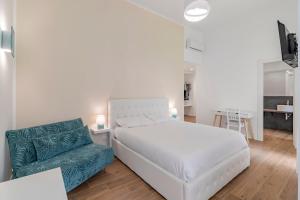 um quarto com uma cama branca e um sofá azul em Leo's Colosseum - Private Apartments em Roma