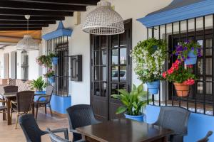 a restaurant with tables and chairs and potted plants at Alojamiento Rural El Sombrero in El Rocío