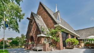 a brick church with a steeple at Het Lichthuis in Zandvoort