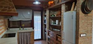 a kitchen with a white refrigerator and a brick wall at Villa Manosalva in Baena