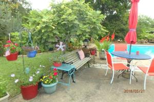 a garden with a bench and tables and potted plants at Poolside Paradise in Navarre