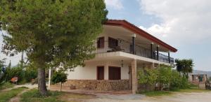 a house with a balcony and a tree at Villa Manosalva in Baena