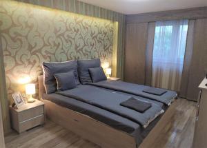 een slaapkamer met een bed met een muur bij Indira Vendégház in Nyíregyháza