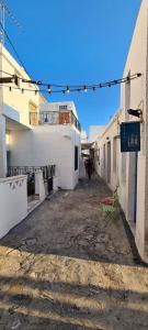 an alley with white buildings and a person walking down it at Traditional House in Skiros
