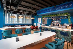 a restaurant with blue walls and tables and blue chairs at Hyatt Place London City East in London