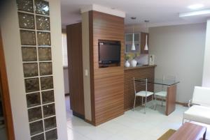 a living room with a tv and a glass table at Flat Life Resort com serviço diário de limpeza in Brasília