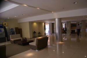 a lobby with couches and chairs in a building at Flat Life Resort com serviço diário de limpeza in Brasília