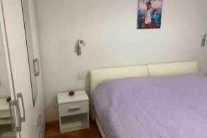 een slaapkamer met een paars bed en een foto aan de muur bij Manuel in Korčula