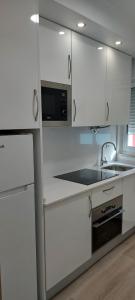 cocina blanca con fregadero y microondas en CASA BIA, en Portimão