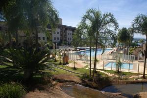 um resort com piscina e palmeiras em Flat Life Resort com serviço diário de limpeza em Brasília
