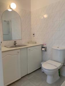 a bathroom with a toilet and a sink and a mirror at King's Palace - very spacious 1 bed apartment in Paphos