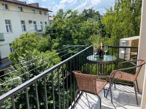 a balcony with two chairs and a table with wine glasses at Modern studio apartment in the city of center in Lviv
