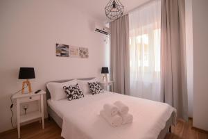 una camera da letto con un letto con due asciugamani sopra di Miralex - Moonlight Residence a Mamaia