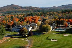 an aerial view of a golf course with fall foliage at The Bethel Resort & Suites in Bethel