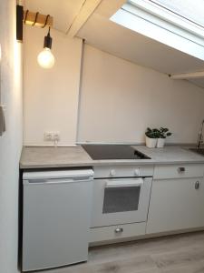 a kitchen with a stove top oven in a room at BUHARDILLA LOFT MUY CÉNTRICA, a 50 m de MARIA PITA y del puerto in A Coruña