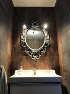 een badkamer met een wastafel en een spiegel aan een muur bij Leśna Willa in Kowalewo +19 foto's