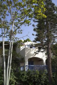 a white house with trees in front of it at Elpida Village in Istro