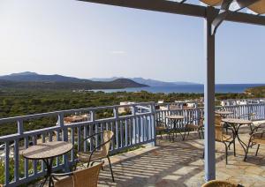 a balcony with tables and chairs and a view of the ocean at Elpida Village in Istro