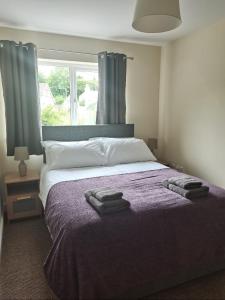 a bedroom with a bed with two towels on it at No2 Glan Nodwydd in Pentraeth