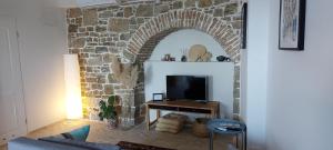 a living room with a stone wall and a tv at Apartment Motovun in Motovun