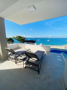 een balkon met een tafel en stoelen en de oceaan bij Villa Mondee in Mandre