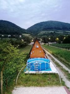 a small house in a field next to a road at Pyramid Energy House in Visoko