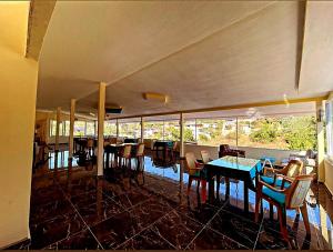 a dining room with tables and chairs and windows at Rose Hotel B&B in Patara