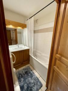 La salle de bains est pourvue d'une baignoire, d'un lavabo et de toilettes. dans l'établissement Appartement 6 personnes Grand Panorama, à Saint-Gervais-les-Bains