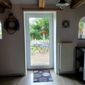 une porte ouverte menant à une terrasse avec une table. dans l'établissement De Olle Uhlhoff, à Barlt