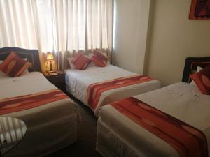 a bed room with two beds and two lamps at Andino Hotel in Machu Picchu