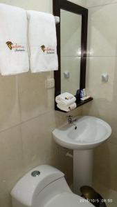 a white toilet sitting next to a sink in a bathroom at Andino Hotel in Machu Picchu