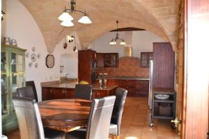 Una cocina con una mesa y sillas de madera en una habitación. en CAL SENYOR DAMIÀ, en Santanyí