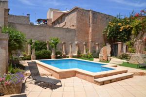 una piscina en un patio con un edificio en CAL SENYOR DAMIÀ, en Santanyí