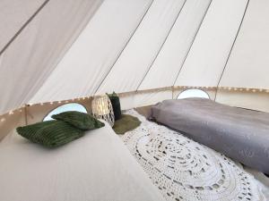 a couple of pillows on a bed in a tent at Kandle talu glämping in Selise