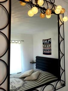 espejo en un dormitorio con cama y ventana en Gite du Manoir des Haies en Les Champs-Géraux