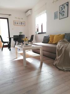 - un salon avec un canapé et une table dans l'établissement Apartment Mare, à Vrsi