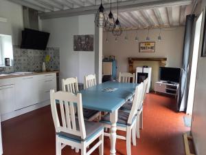 cocina y comedor con mesa azul y sillas en Gîte proche de la Pointe du Hoc CRICQUEVILLE EN BESSIN, en Cricqueville-en-Bessin