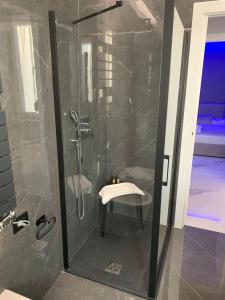 a bathroom with a shower with a stool in it at Temali Apartment in Peschiera del Garda