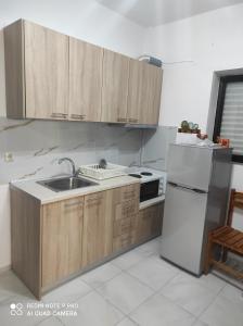 a kitchen with wooden cabinets and a white refrigerator at Iris in Pefkohori