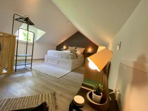 a attic bedroom with a bed and a lamp at Jiwe in Chilleurs-aux-Bois
