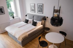um quarto com uma cama, uma mesa e cadeiras em The BL42 - Vienna Concept Apartments em Viena
