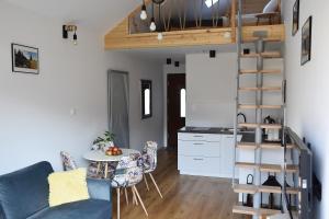a living room with a table and a kitchen at Apartament Bukowy Las in Zachełmie