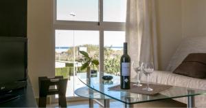 sala de estar con mesa de cristal y 2 copas de vino en Aguamarina Golf 3, en Oliva