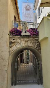 einen Eingang zu einem Gebäude mit einem Tor und Blumen in der Unterkunft Casa Aurelia Bed & Breakfast in Krk