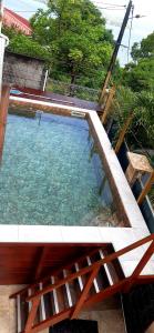 ein großer Pool mit einem Holzzaun um ihn herum in der Unterkunft bas de VILLA LARCHER avec piscine in Le Marin