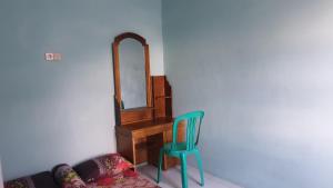 une chaise et un miroir dans la chambre dans l'établissement PanjaluNet Homestay, à Panjalu