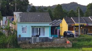 une petite maison blanche dans une rangée de maisons dans l'établissement PanjaluNet Homestay, à Panjalu