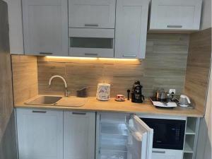 a kitchen with white cabinets and a sink at Gdynia99 in Gdynia