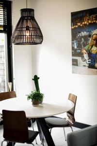 een eetkamer met een tafel en een potplant bij Vakantiehuisje De Barones in Middelburg